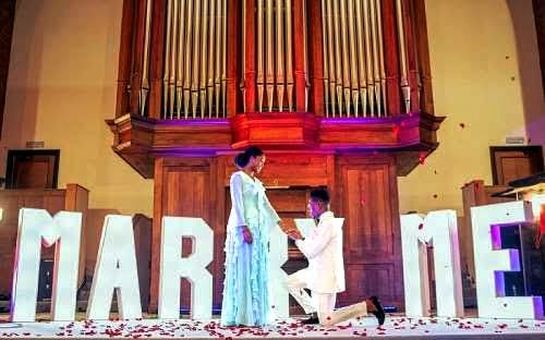 A picture of the Renowned Gospel Singer Moses Bliss on his knees asking his fiancee to be his wife 