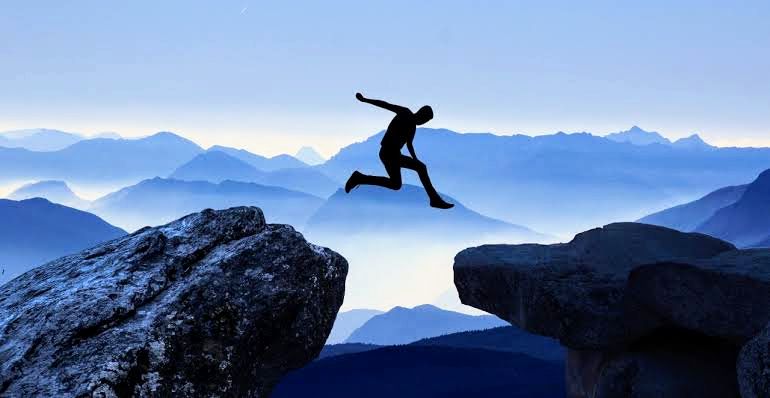An dark-blue animated image of a man jumping from one mountain to the other 