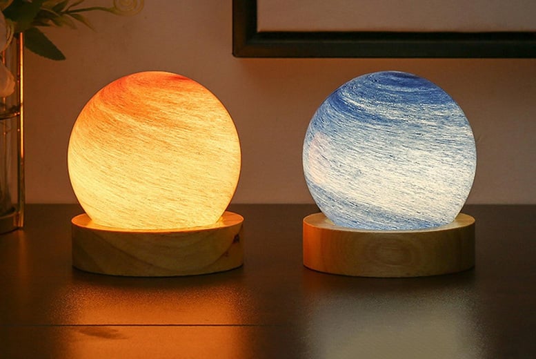 A picture of two night light indicator on a wooden table, one of it is blue while the other is brownish-yellow in colour 