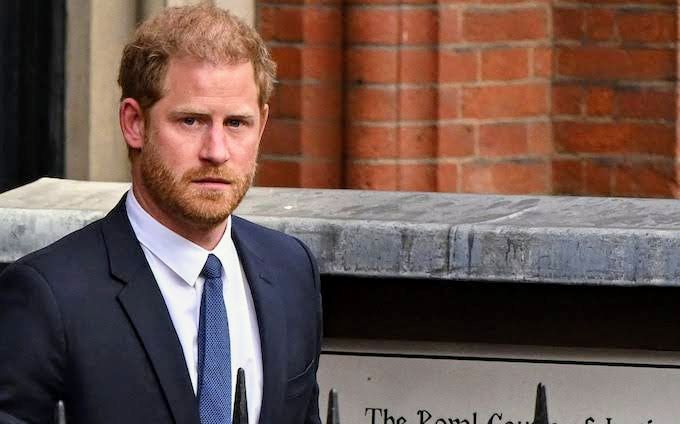A picture of Prince Harry on a black suit, white-inner shirt and a navy blue tie